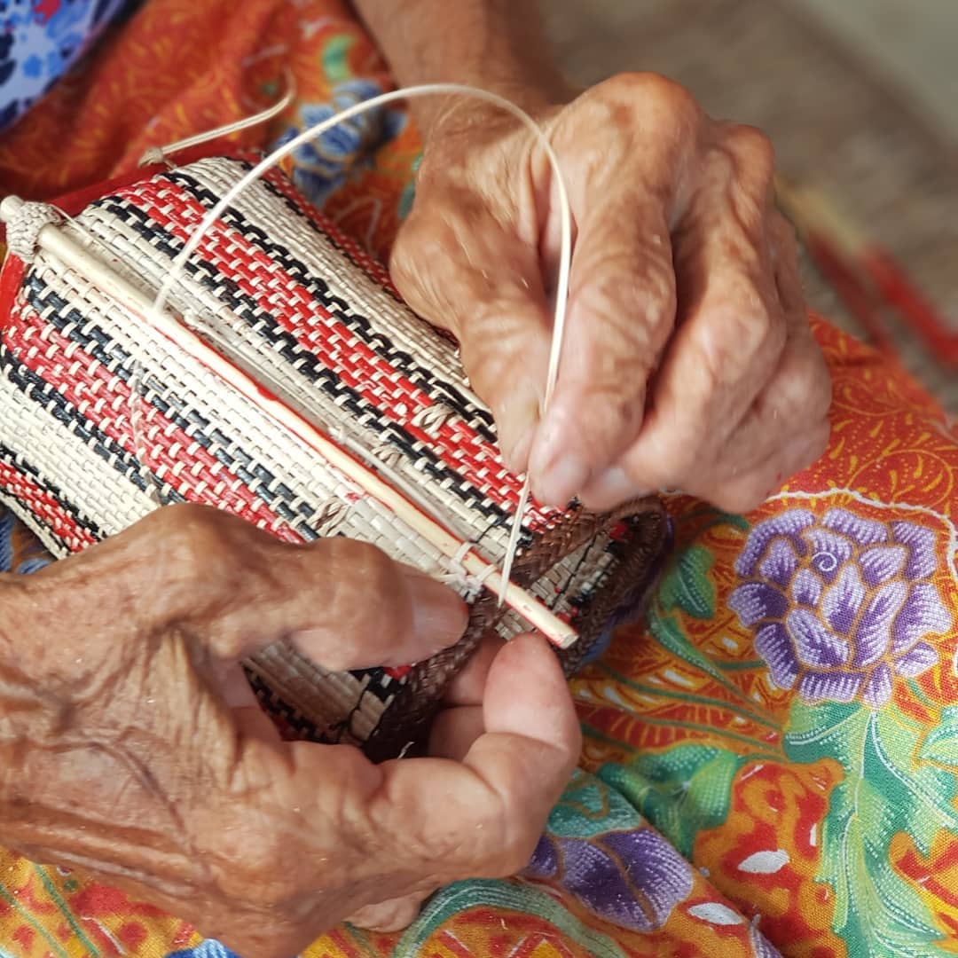 Hands working on a woven textile